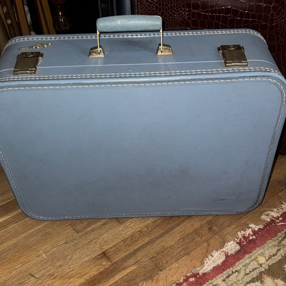 "Vintage Charm: Lady Baltimore Blue Suitcase with Character"